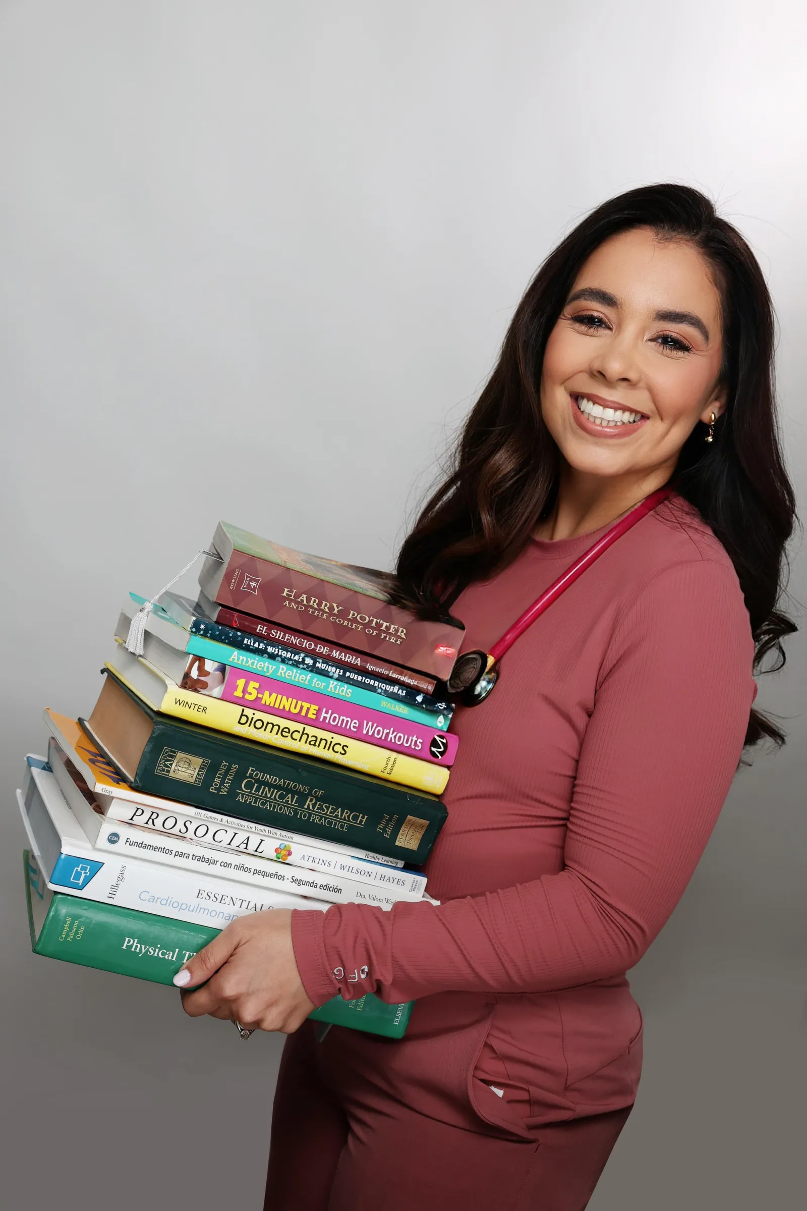 Mariene Ostolaza carrying books on clinical research, biomechanics and child development